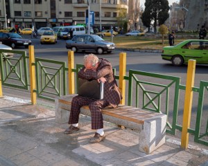 A man sits with his head on his brief case